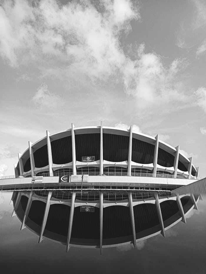pexels-photo-22674728 Black and white reflection of Nigeria's National Theatre building against a cloudy sky.